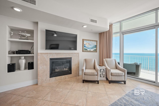 sitting room with baseboards, built in shelves, visible vents, and a fireplace