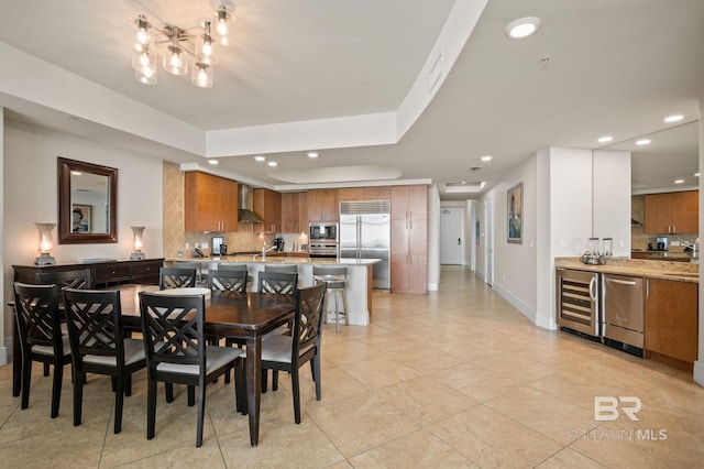 dining space featuring beverage cooler, a tray ceiling, visible vents, and recessed lighting