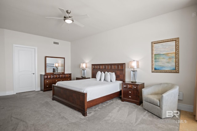 bedroom featuring a ceiling fan, visible vents, light carpet, and baseboards