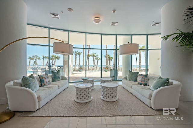 tiled living area with a healthy amount of sunlight, visible vents, and floor to ceiling windows