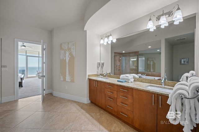 bathroom with double vanity, a stall shower, a sink, and tile patterned floors