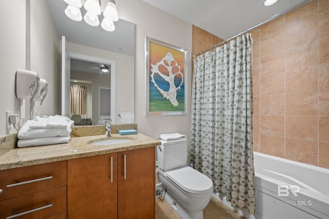 bathroom with toilet, ceiling fan with notable chandelier, shower / bath combo with shower curtain, and vanity