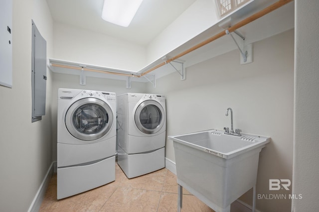 washroom with a sink, washer and dryer, laundry area, electric panel, and baseboards