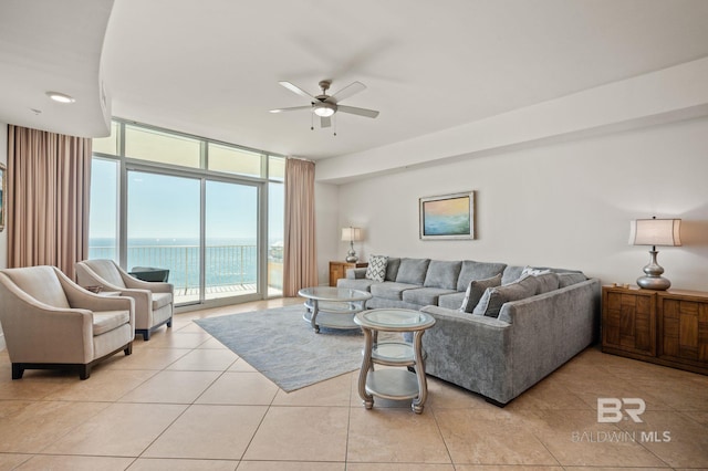 living room featuring expansive windows, light tile patterned flooring, and a ceiling fan