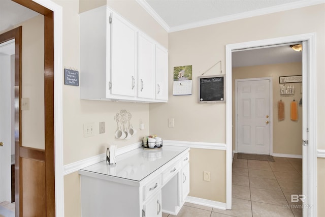 7431 Summer Ct, Mobile, AL 36695 - kitchen featuring light tile patterned floors, ornamental molding, white cabinets, light countertops, and baseboards