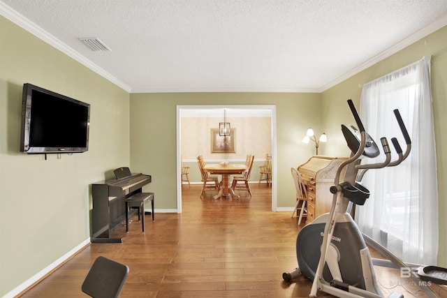 7431 Summer Ct, Mobile, AL 36695 - exercise room with hardwood / wood-style floors, a textured ceiling, crown molding, and baseboards