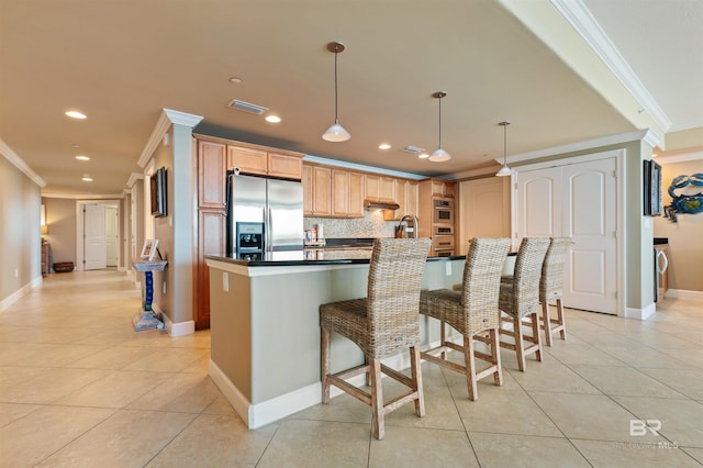 kitchen featuring light tile patterned floors, visible vents, ornamental molding, and stainless steel refrigerator with ice dispenser