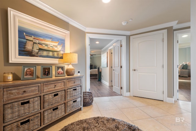 hall with light tile patterned flooring, baseboards, and ornamental molding