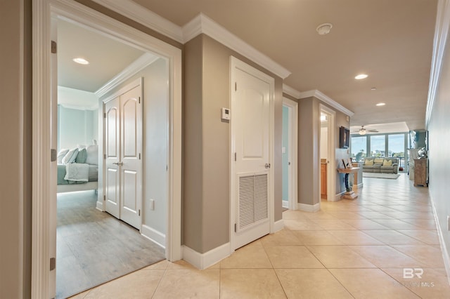 hall with light tile patterned flooring, recessed lighting, crown molding, and baseboards