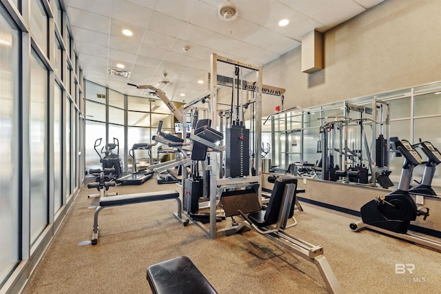 gym with a high ceiling, recessed lighting, a paneled ceiling, and visible vents