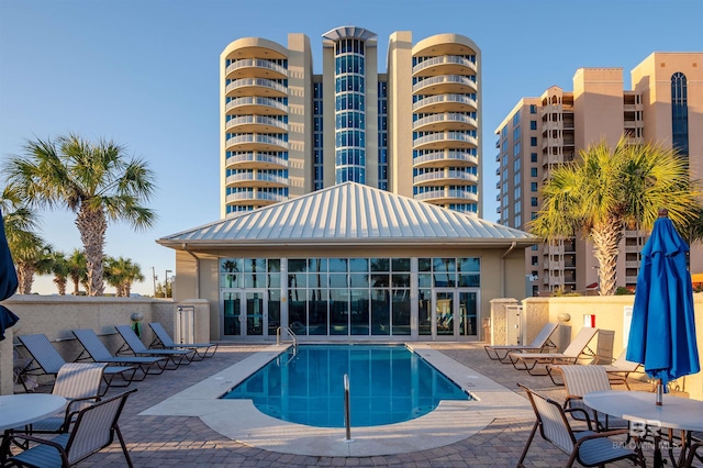 community pool with french doors and a patio