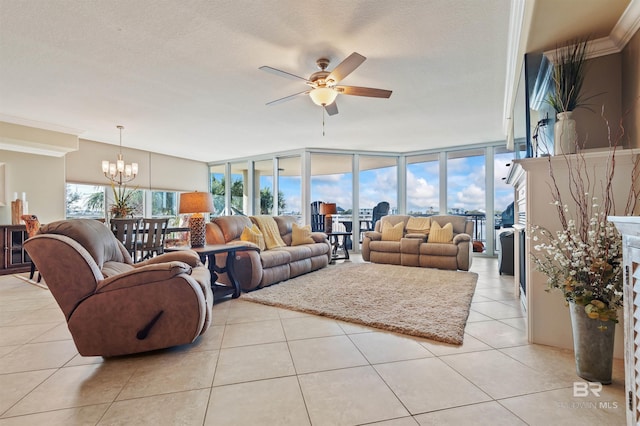 living room with crown molding, expansive windows, ceiling fan with notable chandelier, light tile patterned flooring, and a textured ceiling