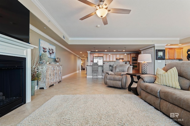 living room with light tile patterned floors, a fireplace, baseboards, and ornamental molding