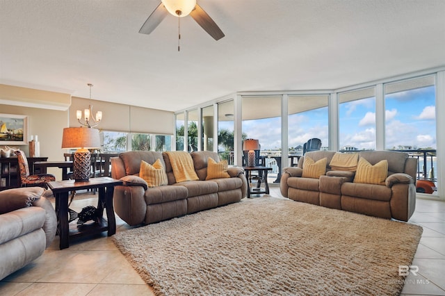 living room with floor to ceiling windows, light tile patterned flooring, and ceiling fan with notable chandelier