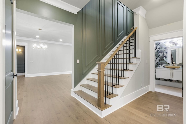845 Inlet Cir, Gulf Shores, AL 36542 - stairway featuring a chandelier, wood finished floors, and crown molding