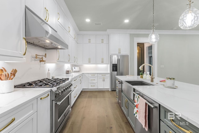 845 Inlet Cir, Gulf Shores, AL 36542 - kitchen with stainless steel appliances, under cabinet range hood, white cabinetry, light stone countertops, and wood finished floors