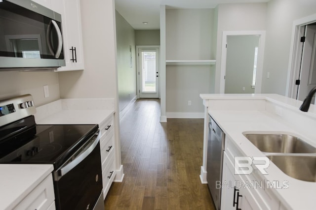 kitchen with sink, dark wood-type flooring, stainless steel appliances, and white cabinets