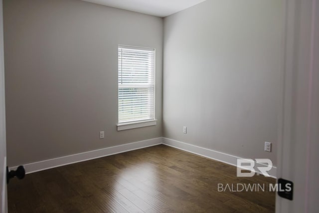 unfurnished room with dark wood-type flooring