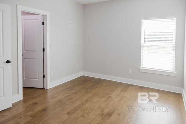 unfurnished room featuring a wealth of natural light and hardwood / wood-style floors