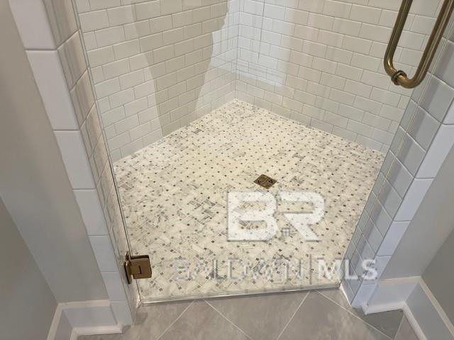 bathroom with tile patterned flooring and tiled shower