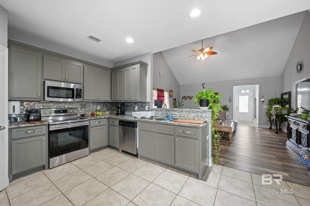 1206 Crown Walk Dr, Foley, AL 36535 - kitchen featuring gray cabinetry, light tile patterned flooring, kitchen peninsula, and appliances with stainless steel finishes