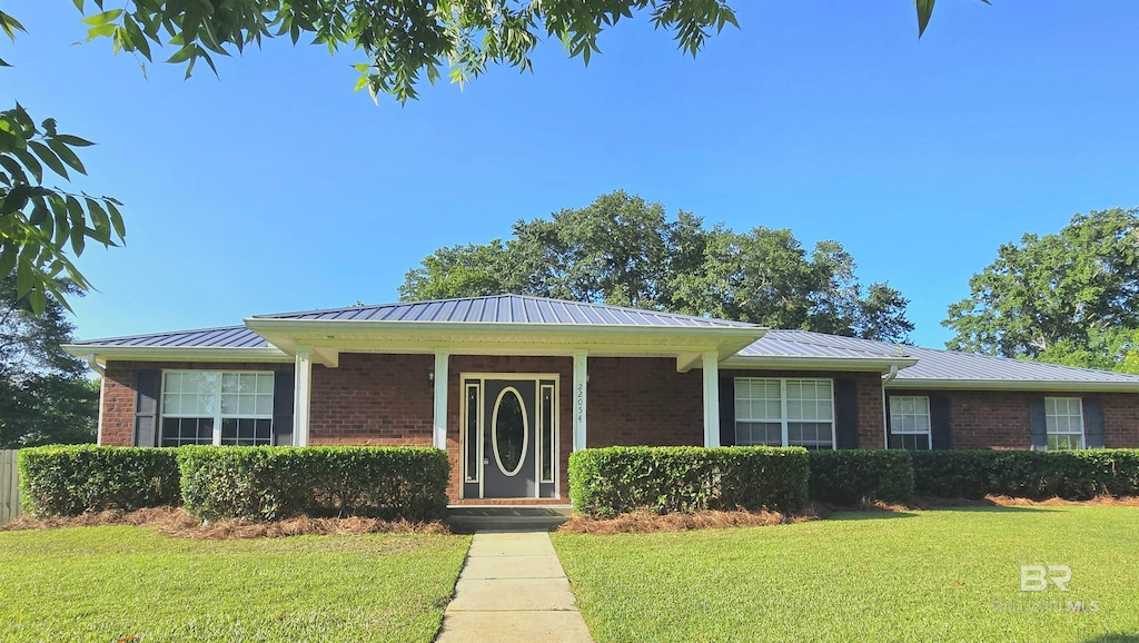 22054 S Stoddard St, Robertsdale, AL 36567 - ranch-style house with brick siding, a front yard, and metal roof