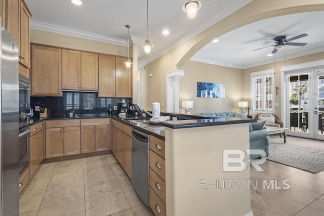 kitchen featuring arched walkways, stainless steel appliances, open floor plan, and dark countertops