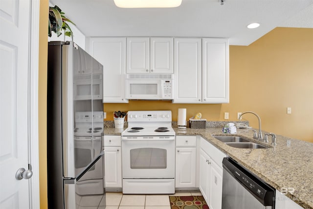kitchen featuring appliances with stainless steel finishes, white cabinetry, and a sink