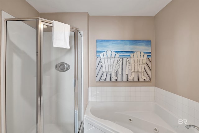 bathroom featuring a shower stall and a tub with jets