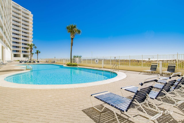 pool with fence and a patio