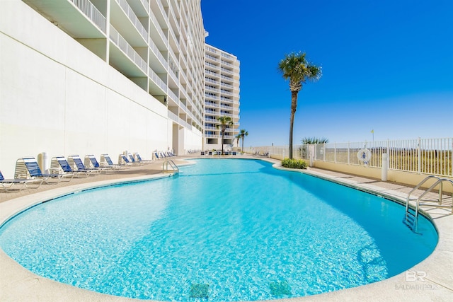pool featuring fence and a patio