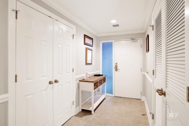 interior space with light tile patterned floors, visible vents, and crown molding