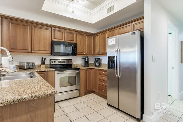 401 E Beach Blvd Unit 1302, Gulf Shores, AL 36542 - kitchen with a sink, a tray ceiling, light tile patterned flooring, and stainless steel appliances