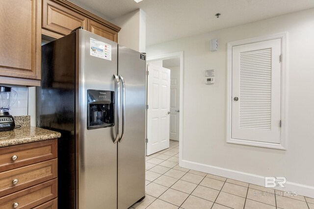 401 E Beach Blvd Unit 1302, Gulf Shores, AL 36542 - kitchen featuring brown cabinetry, baseboards, light tile patterned flooring, and stainless steel fridge