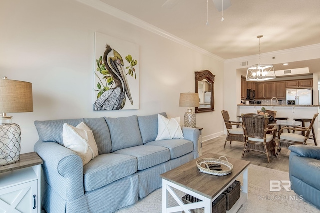 401 E Beach Blvd Unit 1302, Gulf Shores, AL 36542 - living room with ornamental molding, baseboards, a notable chandelier, and light wood-style floors