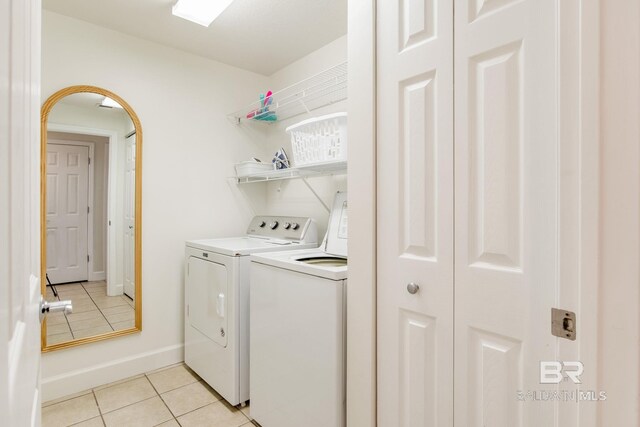 401 E Beach Blvd Unit 1302, Gulf Shores, AL 36542 - washroom featuring laundry area, light tile patterned floors, arched walkways, baseboards, and washer and clothes dryer