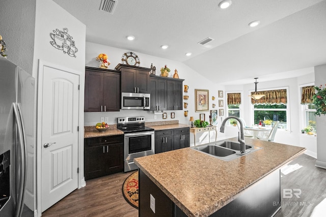 23038 Ridgewood Dr, Robertsdale, AL 36567 - kitchen featuring stainless steel appliances, a sink, lofted ceiling, dark wood-type flooring, and a kitchen island with sink
