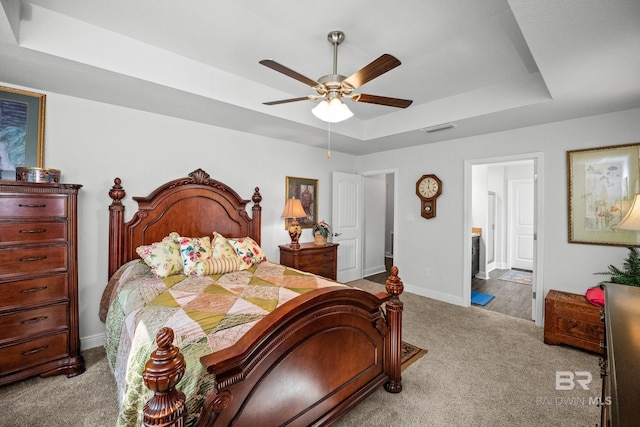 23038 Ridgewood Dr, Robertsdale, AL 36567 - carpeted bedroom featuring a raised ceiling, baseboards, ensuite bathroom, and a ceiling fan