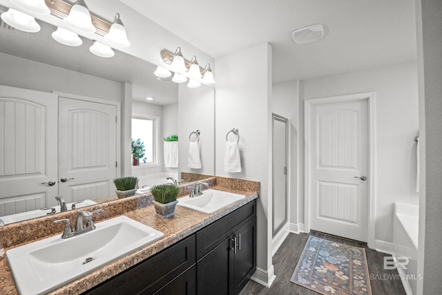 23038 Ridgewood Dr, Robertsdale, AL 36567 - full bathroom featuring double vanity, a stall shower, wood finished floors, and baseboards