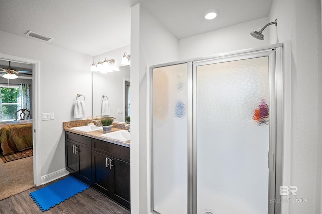 23038 Ridgewood Dr, Robertsdale, AL 36567 - bathroom with ensuite bath, a shower stall, wood finished floors, double vanity, and baseboards
