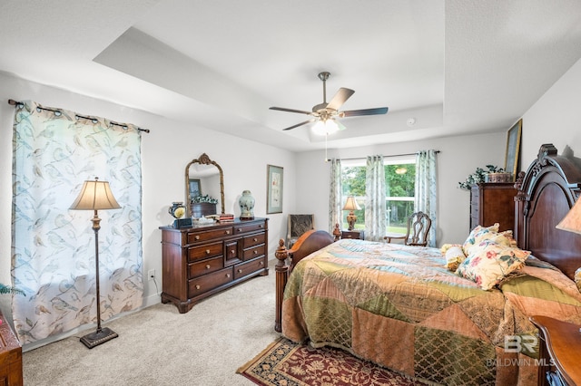 23038 Ridgewood Dr, Robertsdale, AL 36567 - bedroom featuring a raised ceiling, light colored carpet, and a ceiling fan
