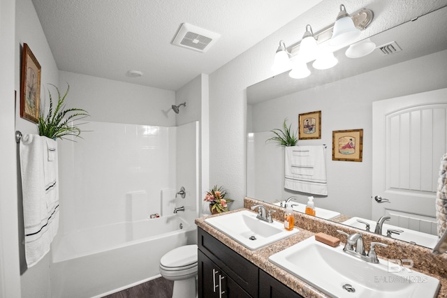 23038 Ridgewood Dr, Robertsdale, AL 36567 - full bathroom with double vanity, toilet,  shower combination, wood finished floors, and a textured ceiling