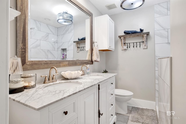 full bathroom with double vanity, visible vents, toilet, and a sink