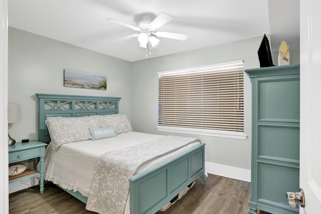 bedroom featuring a textured ceiling, a ceiling fan, dark wood-type flooring, and baseboards