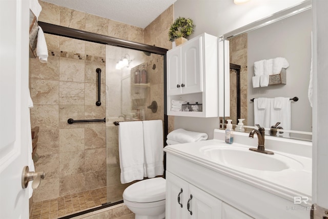 bathroom featuring toilet, a textured ceiling, tiled shower, and vanity