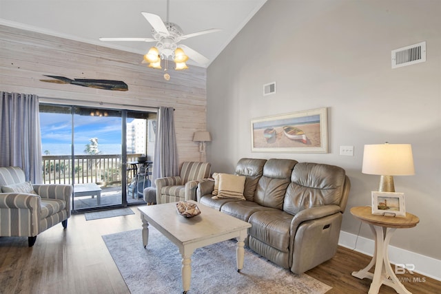 living area featuring visible vents, high vaulted ceiling, a ceiling fan, and wood finished floors