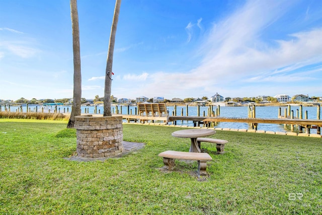 view of dock featuring a lawn and a water view