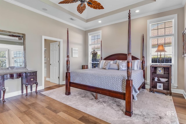 bedroom featuring light hardwood / wood-style flooring, ceiling fan, ornamental molding, and multiple windows