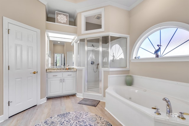 bathroom featuring vanity, ornamental molding, wood-type flooring, and separate shower and tub