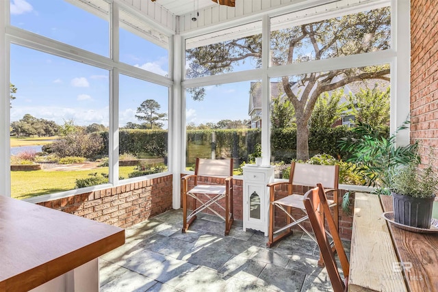 sunroom featuring a water view